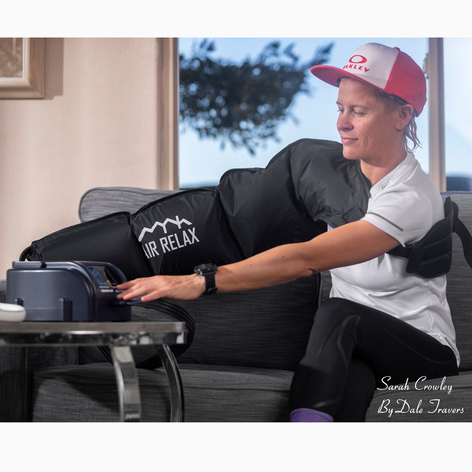 AIR RELAX AR-3.0 & AR-2.0 ARM SLEEVE — Woman wearing arm sleeve while operating pump on couch