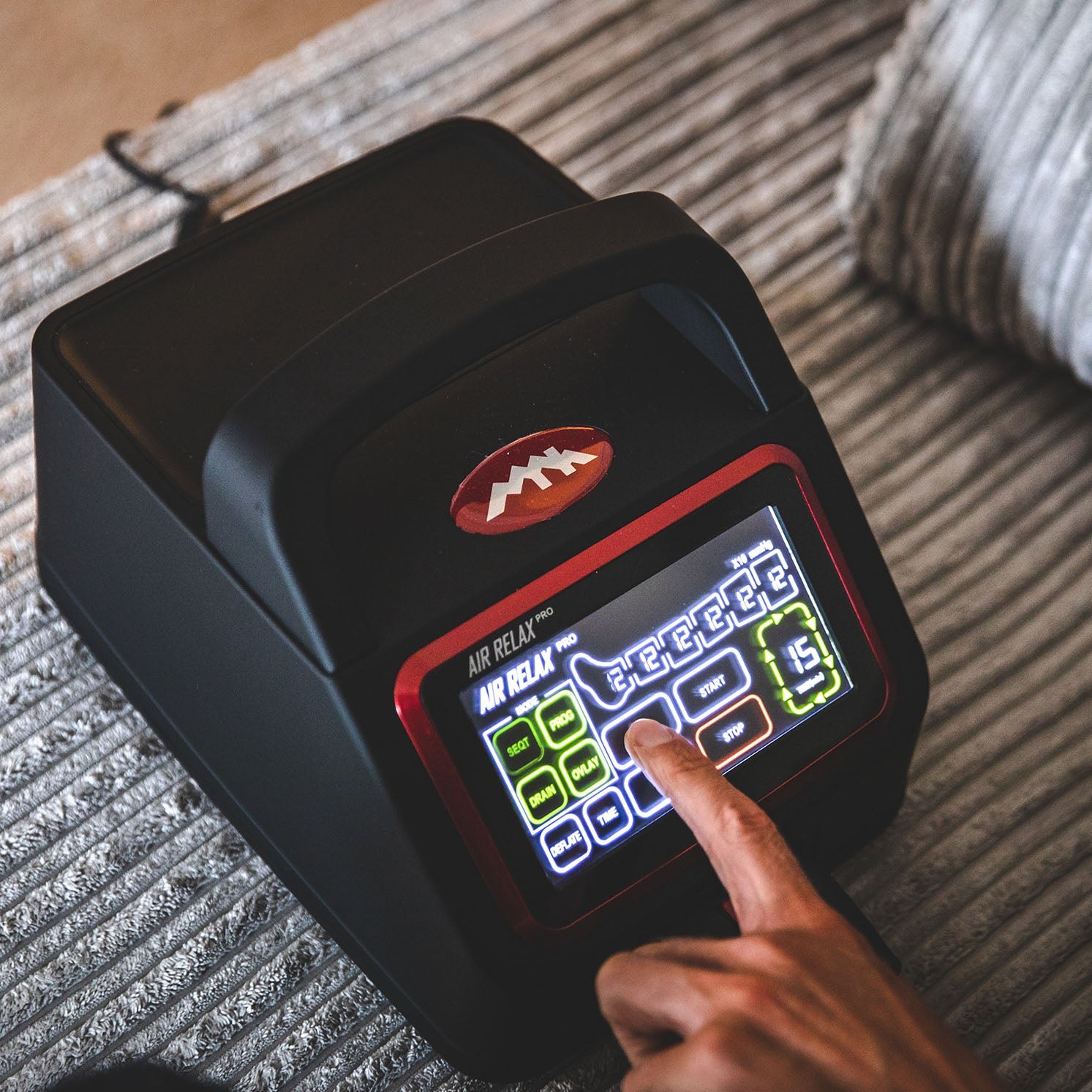 AIR RELAX PRO AR-4.0 LEG RECOVERY SYSTEM — Hand interacting with the touch screen of Air Relax Pro control unit